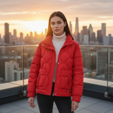 Woman wearing a red puffer jacket with a city skyline in the background