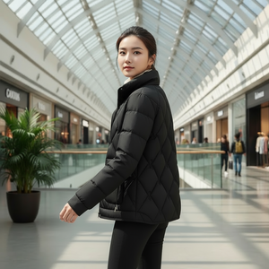 Woman wearing a black puffer jacket in a modern shopping mall.