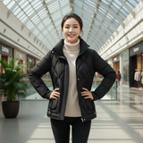 Woman wearing a black jacket in a modern indoor setting