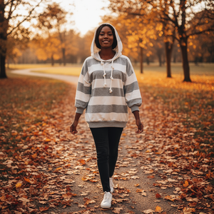 Woman walking in a park with autumn leaves and trees in the background