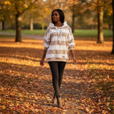 Woman walking in a park with autumn leaves and trees in the background