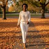 Woman walking on a path with autumn leaves in a park