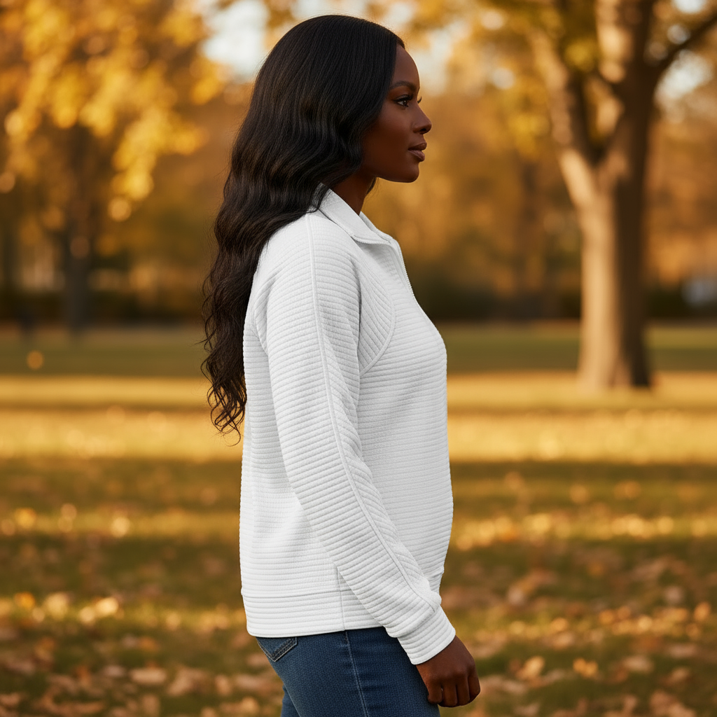 Woman in a white sweater standing in an autumn park