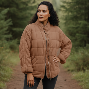 Woman wearing a brown quilted jacket in a forest setting