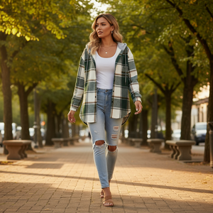 Woman walking on a tree-lined street wearing a plaid shirt and ripped jeans.