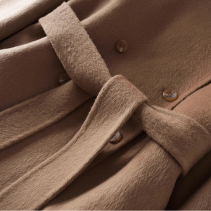 Close-up of a brown coat with a belt and buttons